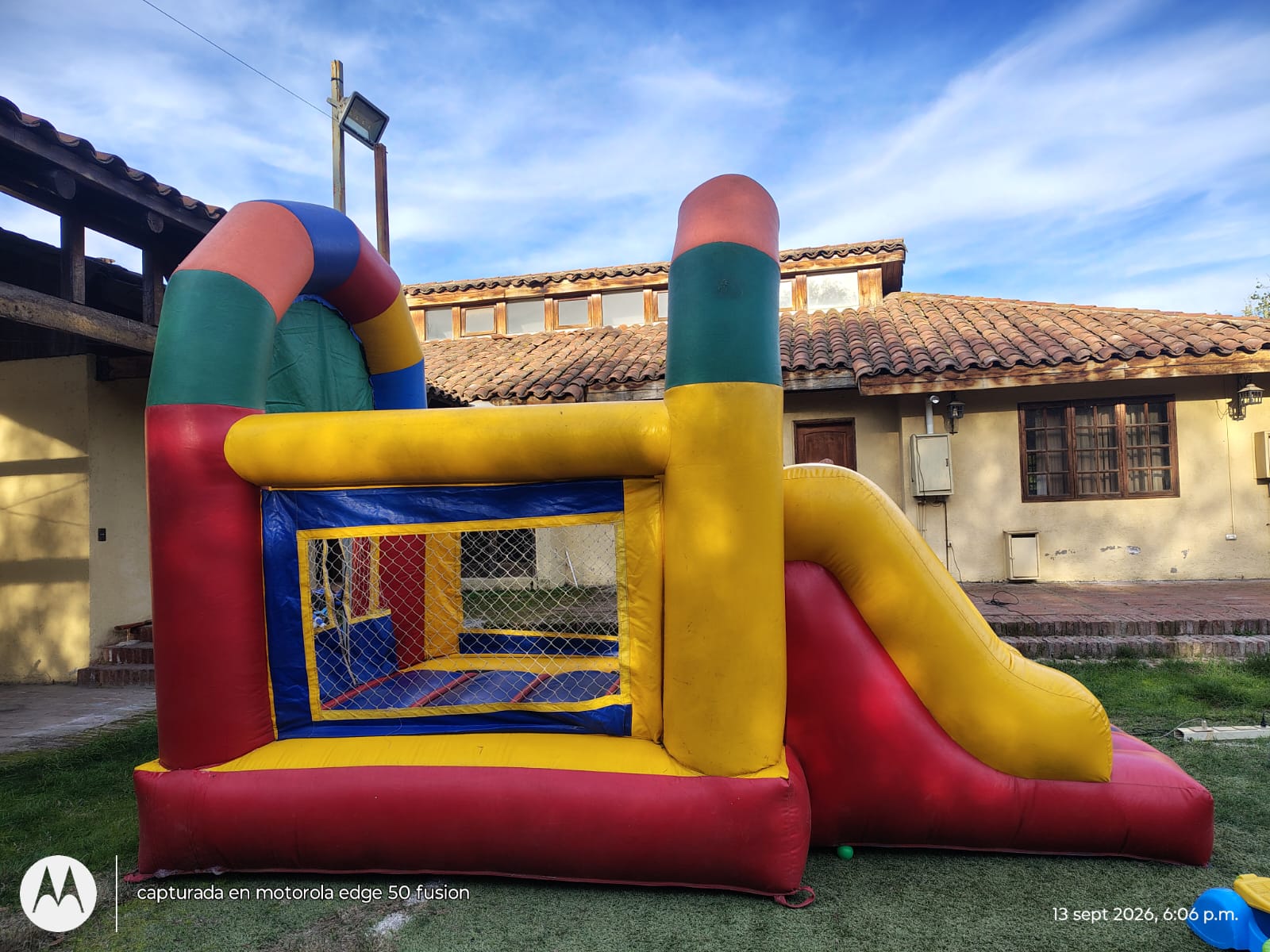 Castillo inflable multicolor con resbalín en un patio de celebración
